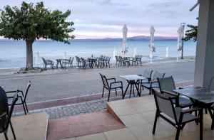 un grupo de mesas y sillas en la playa en Horizon en Pefkohori