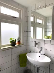 a white bathroom with a sink and a mirror at Apartment In de Wolken in Oostwoud +6 photos