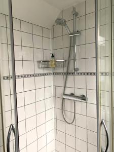 een douche met een douchekop in de badkamer bij Apartment De Vliegenzwam in Oostwoud