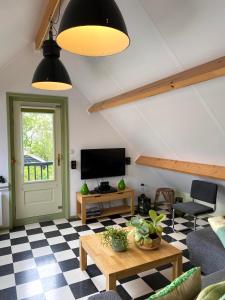 ein Wohnzimmer mit einem schwarz-weiß karierten Boden in der Unterkunft Apartment De Vliegenzwam in Oostwoud