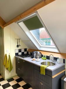 a kitchen with a sink and a window at Apartment In de Wolken in Oostwoud