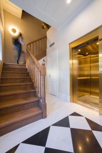 a woman walking down the stairs in a lobby at Castellano Hotel & Suites in Nafplio