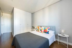 a bedroom with a bed and a white wall at JA Suites Madrid in Madrid
