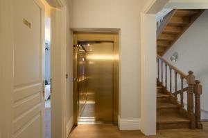 a hallway with a gold elevator in a house at Castellano Hotel & Suites in Nafplio