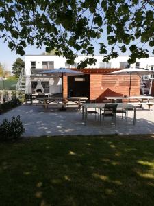 un grupo de mesas de picnic y un pabellón en un parque en Nuvola East en Zottegem
