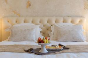 a tray with a plate of food on a bed at Castellano Hotel & Suites in Nafplio