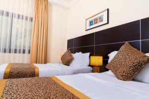 a hotel room with two beds and a window at Platinum Seventy in Jeddah