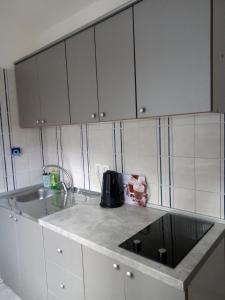 a kitchen with white cabinets and a sink at KATY&MLADEN in Baška