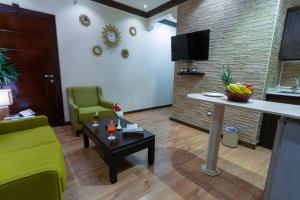 a living room with a couch and a table and a tv at Platinum Seventy in Jeddah