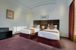 a hotel room with two beds and a piano at Platinum Seventy in Jeddah