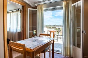a dining room with a table and a balcony at Casablanca Hotel Studios in Santa Marta de Tormes