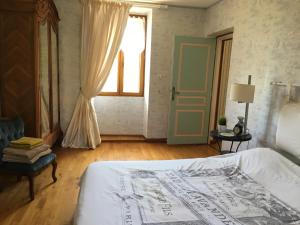 ein Schlafzimmer mit einem weißen Bett und einem Fenster in der Unterkunft Maison Cardeillac in Haget