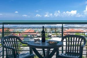 una mesa con una botella y dos copas de vino en Hotel Paris, en Lido di Camaiore