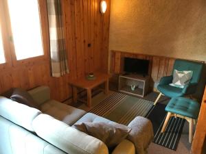 a living room with a couch and a chair and a television at Chalet Le Cordava in Tignes