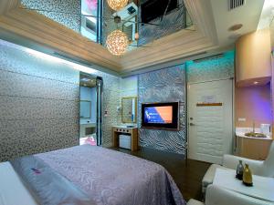 a bedroom with a bed and a tv on a wall at Lai Yin Motel in Longtan