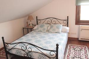 a bedroom with a bed with blue and white sheets and pillows at Quinta Sobral Prestige - Rustic House in Sobral de Monte Agraço +46 photos