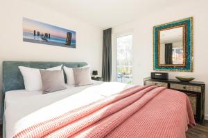 1 dormitorio con 1 cama grande y espejo en 5 Sterne-Ferienhaus-See-Sauna-Kamin-Garten im Naturpark en Krakow am See