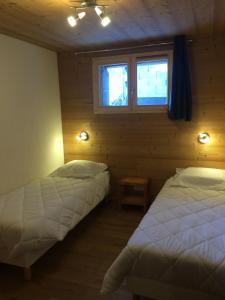 a bedroom with two beds and a window at La Datcha*** 4-5 personnes in Bonneval-sur-Arc