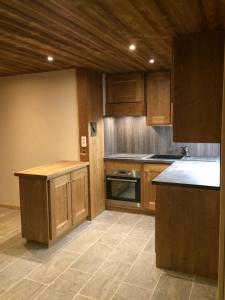 a kitchen with wooden cabinets and a tile floor at La Datcha*** 4-5 personnes in Bonneval-sur-Arc