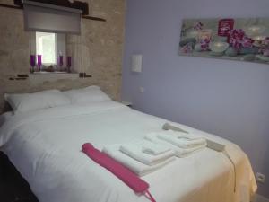 a white bed with three folded towels on it at Les Rosiers in Chaunay