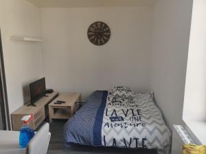 ein Schlafzimmer mit einem Bett und einer Uhr an der Wand in der Unterkunft Calme 2 Pièces en Duplex in Aufferville