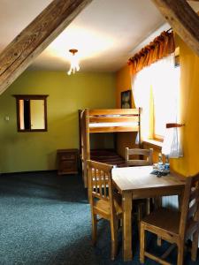 - une salle à manger avec une table et des lits superposés dans l'établissement Karczma Młyn, à Kamienica