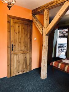 - une chambre avec une porte en bois et des lits superposés dans l'établissement Karczma Młyn, à Kamienica