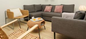 ein Wohnzimmer mit einer Couch und Stühlen und einem Tisch in der Unterkunft Home Sweet Home Main St Pamplona in Pamplona