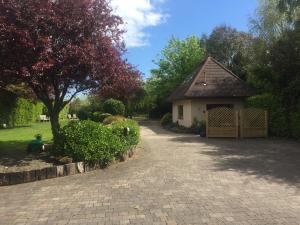 a brick driveway leading to a house with a tree at The Lodge at Bodenlodge in Malahide