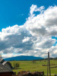 a cloudy sky with a field and a pole at Dom u Kasi in Podwilk