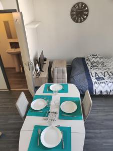 ein Wohnzimmer mit einem Tisch mit Tellern darauf in der Unterkunft Calme 2 Pièces en Duplex in Aufferville