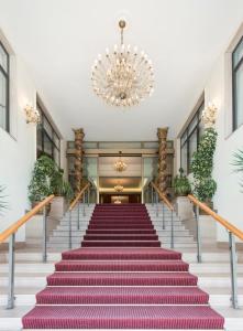 eine Treppe in einem Gebäude mit einem Kronleuchter in der Unterkunft Grand Hotel Adriatico in Montesilvano