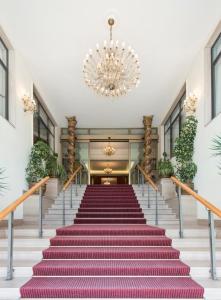 a staircase in a building with a chandelier at Grand Hotel Adriatico in Montesilvano