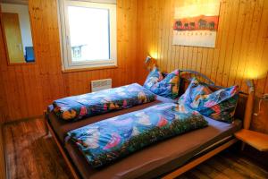 RosswaldにあるChalet Fletschhornのベッド2台、枕、窓が備わる客室です。