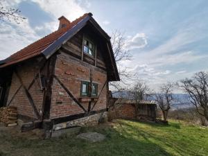 an old brick house on a grassy hill at Chalet Belino sokače in Užice