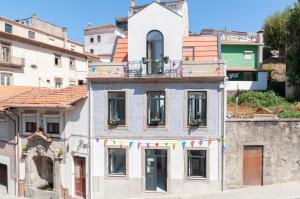 
a small building with a clock on the side of it at Porto Moments Apartments in Vila Nova de Gaia

