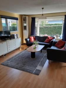 a living room with two couches and a coffee table at Zonnig zomerhuis in Krachtighuizen