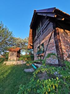 an old wooden house with a window on a yard at Chalet Belino sokače in Užice