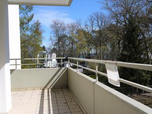 einen Balkon mit weißem Geländer und Bäumen in der Unterkunft Strandperle 1 Timmendorfer Strand in Timmendorfer Strand