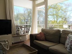 ein Wohnzimmer mit einem Sofa und einem großen Fenster in der Unterkunft Strandperle 1 Timmendorfer Strand in Timmendorfer Strand