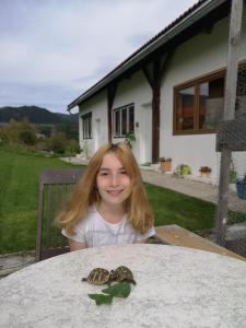 a little girl sitting at a table with two turtles at Apartment Rappitsch in Sankt Marein bei Knittelfeld