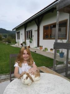 uma jovem sentada à mesa com um gato em Apartment Rappitsch em Sankt Marein bei Knittelfeld