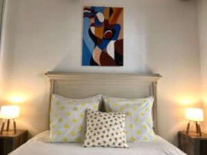 Un dormitorio con una cama con una pintura encima. en La Maison du Courtil, Citron-Caramel en Moustiers-Sainte-Marie