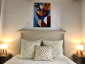a bedroom with a bed with a painting above it at La Maison du Courtil, Citron-Caramel in Moustiers-Sainte-Marie +19 photos