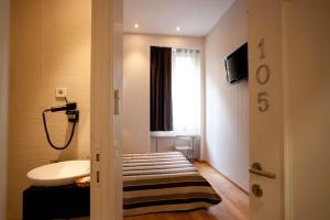 Un baño con lavabo, inodoro y ventana. en Hostal Bcn 46, en Barcelona