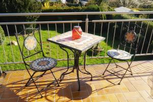 einen Tisch mit 2 Stühlen und eine Vase auf dem Balkon in der Unterkunft Ferienwohnung Himmelreich in Bernkastel-Kues