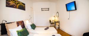 a living room with a white couch and a tv at Alagoa Terrace Guesthouse in Faro
