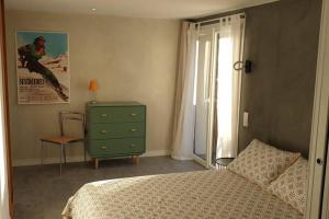 1 dormitorio con 1 cama, vestidor y ventana en Le petit appart de Pomme, en Embrun