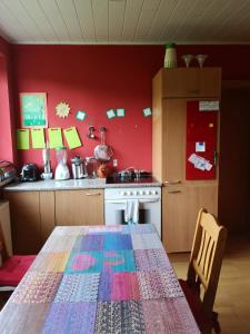 uma cozinha com uma mesa e uma parede vermelha em Apartment Rappitsch em Sankt Marein bei Knittelfeld