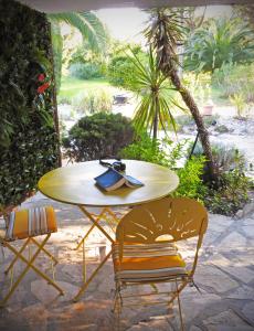 una mesa y dos sillas con un libro. en La Villa Les Hespérides en Grimaud